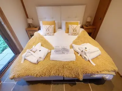a bedroom with a bed with towels on it at Swn Y Nant Lodge with hot tub Brecon in Brecon