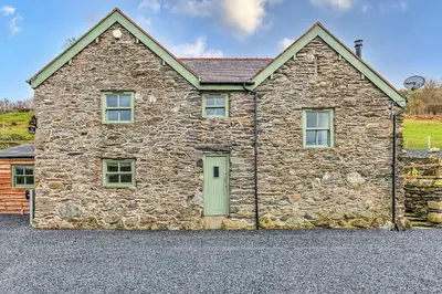 a large stone house with a green door at Finest Retreats - Moelis Barn in Llandrillo