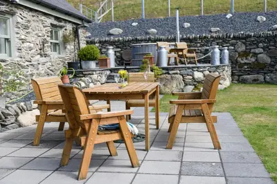 a wooden table and chairs on a patio at Finest Retreats - Moelis Barn in Llandrillo