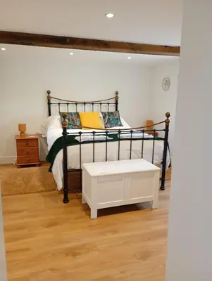 a bedroom with a black and white bed with a bench at Finest Retreats - Moelis Barn in Llandrillo