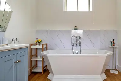 a white bath tub in a kitchen with a sink at Finest Retreats - Moelis Barn in Llandrillo