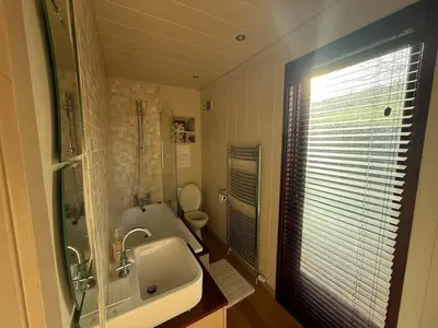 a bathroom with a sink and a tub and a toilet at Charming 2 bedroom Lodge In the Shropshire Countryside with Fantastic Views in Clunton