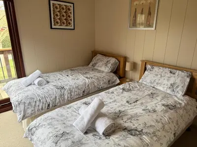 two beds sitting next to each other in a bedroom at Charming 2 bedroom Lodge In the Shropshire Countryside with Fantastic Views in Clunton