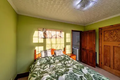 a bedroom with a bed with green walls and a window at Finest Retreats - Tan y Fron Hideaway in Dyffryn