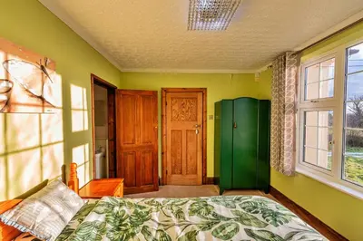 a bedroom with a bed and a green door at Finest Retreats - Tan y Fron Hideaway in Dyffryn