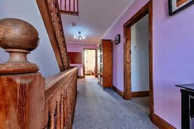 a hallway with a wooden staircase and a mirror at Finest Retreats - Tan y Fron Hideaway in Dyffryn