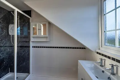 a bathroom with a sink and a glass shower at Finest Retreats - Tan y Fron Hideaway in Dyffryn