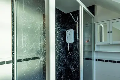 a shower in a bathroom with a glass shower backdoor at Finest Retreats - Tan y Fron Hideaway in Dyffryn