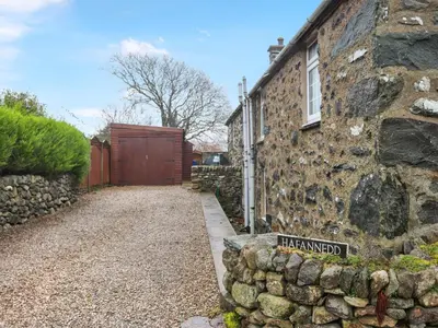 a stone house with a sign in front of it at Hafanedd in Dyffryn