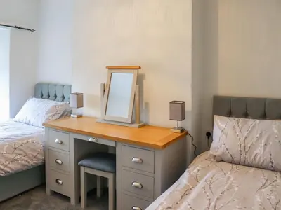 a bedroom with a dresser with a mirror and a bed at Hafanedd in Dyffryn