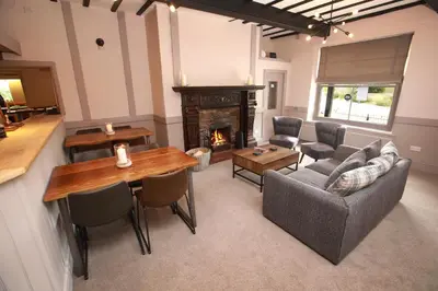 a living room with a table and a fireplace at OYO Glyn Valley Hotel in Glyn-Ceiriog