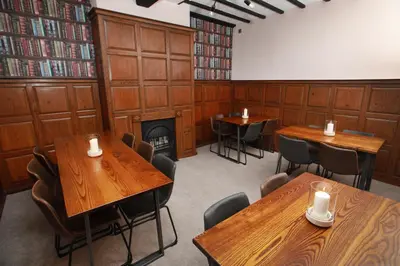 a room with wooden tables and chairs and a fireplace at OYO Glyn Valley Hotel in Glyn-Ceiriog