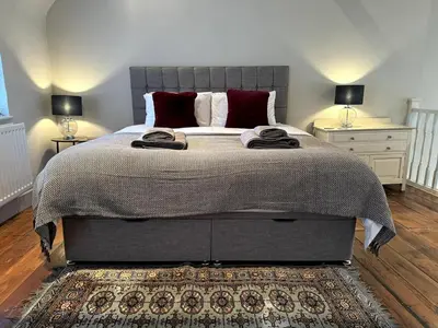 a bedroom with a large bed with two night stands at The Cottage, Upper Linney, Ludlow in Ludlow