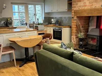 a living room with a couch and a table in a kitchen at The Cottage, Upper Linney, Ludlow in Ludlow