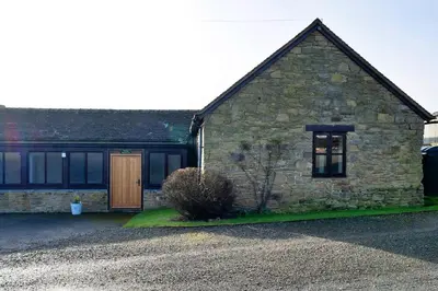 an old stone house with a gravel driveway at Finest Retreats - Walton Maisonette in Onibury