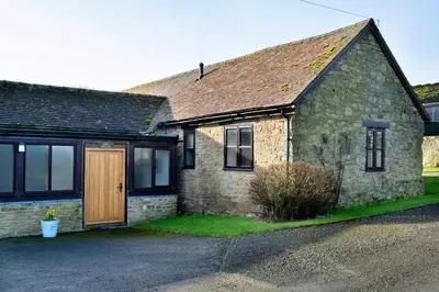 an old stone house with a wooden door at Finest Retreats - Walton Maisonette in Onibury