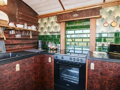 a kitchen with a stove top oven in a kitchen at GWR Wagon - Victoria Station in Craven Arms