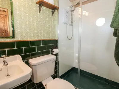 a bathroom with a toilet and a sink and a shower at GWR Wagon - Victoria Station in Craven Arms