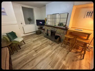 a living room with a fireplace and a table and chairs at Golygfa'r Orsaf Snowdonia national park, Bala lake in Bala