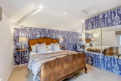 a bedroom with a large bed with blue and white wallpaper at 14 Bed in Llansanffraid oc-b30382 in Llanymynech