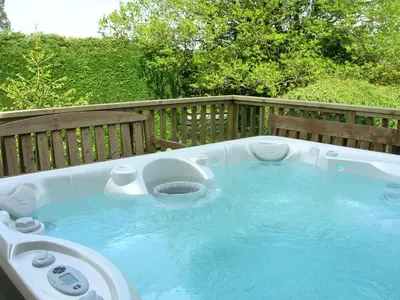 a jacuzzi tub sitting on a deck at Bevan House with Hot Tub in Mid-Wales in Hundred House