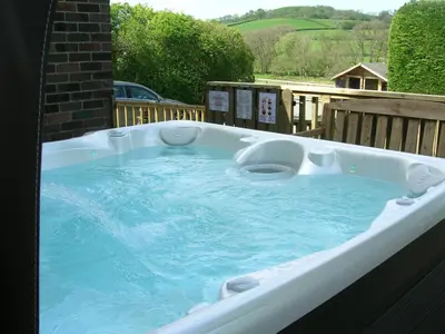 a jacuzzi tub on top of a patio at Bevan House with Hot Tub in Mid-Wales in Hundred House