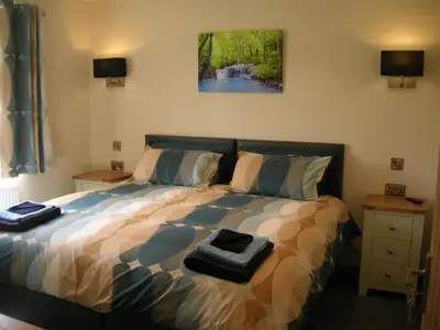 a bedroom with a bed with two towels on it at River Lodge Hot Tub Sleeps 6 in Hundred House