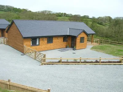 a house with a large driveway in front of it at River Lodge Hot Tub Sleeps 6 in Hundred House