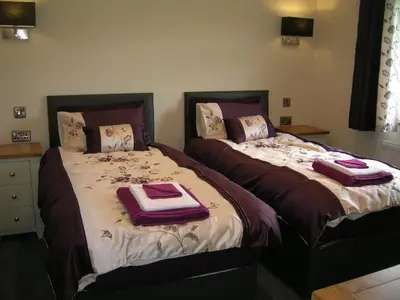 two beds sitting next to each other in a bedroom at River Lodge Hot Tub Sleeps 6 in Hundred House