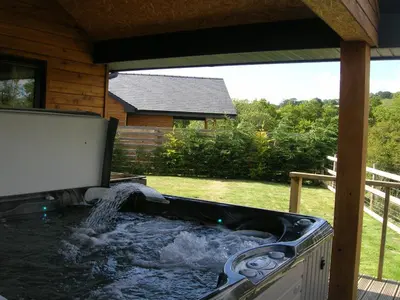 a hot tub with a waterfall in a backyard at Woodland Lodge Hot Tub Sleeps 6 in Hundred House