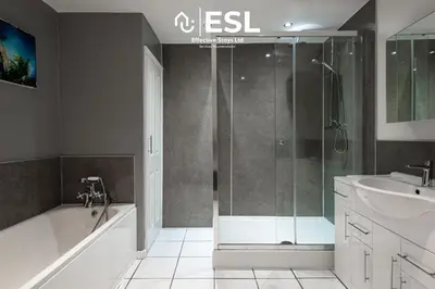 a bathroom with a shower and a tub and a sink at 2 Bed Townhouse with Garden & Parking in Shrewsbury