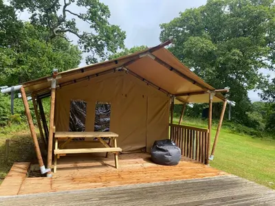 a tent with a wooden deck in a field at Cefn Crib Safari Tent in Machynlleth