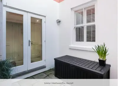 a window and a bench in front of a house at Westhaven 5 Beachfront Luxury-Free parking permit in Aberdyfi