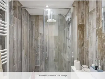 a bathroom with a shower with a toilet and a sink at Westhaven 5 Beachfront Luxury-Free parking permit in Aberdyfi