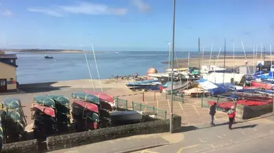 a group of cars parked on a beach with boats at Westhaven 5 Beachfront Luxury-Free parking permit in Aberdyfi