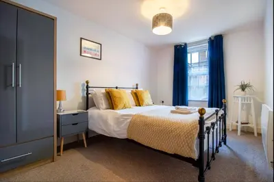 a bedroom with a bed with yellow pillows and a window at 2 bedroom apartment - Shrewsbury town centre in Shrewsbury