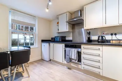 a kitchen with white cabinets and a counter top at 2 bedroom apartment - Shrewsbury town centre in Shrewsbury