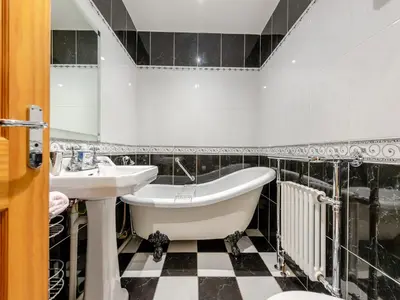 a bathroom with a bath tub and a sink at Y Cartws in Llanybydder