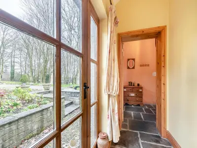 a door leading to a room with a window at Y Cartws in Llanybydder