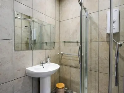 a bathroom with a sink and a shower at The Old Milking Parlour in Melverley