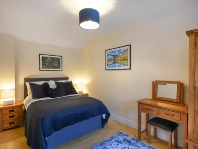 a bedroom with a bed and a mirror and a television at The Old Milking Parlour in Melverley