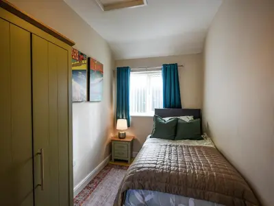 a small bedroom with a bed and a window at The Old Milking Parlour in Melverley