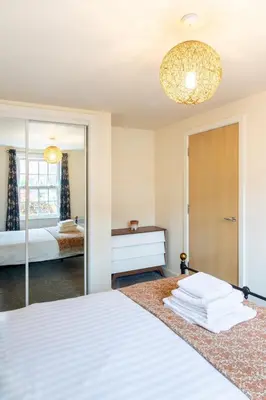 a bedroom with a white bed and a mirror at 1-bedroom apartment Shrewsbury town centre in Shrewsbury