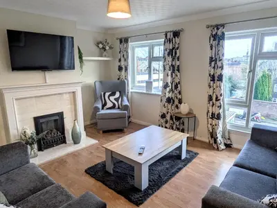a living room with a fireplace and a tv at Theatre Severn Town House, Parking & Quarry Views in Shrewsbury