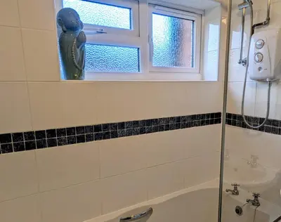 a bathroom with a shower and a tub and a window at Theatre Severn Town House, Parking & Quarry Views in Shrewsbury