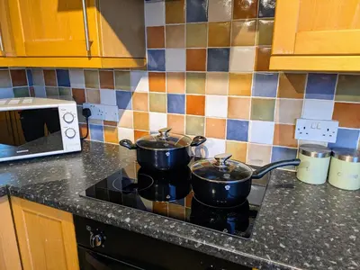 two pots sitting on top of a stove in a kitchen at Theatre Severn Town House, Parking & Quarry Views in Shrewsbury