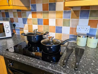 two pots sitting on top of a stove in a kitchen at Theatre Severn Town House, Parking & Quarry Views in Shrewsbury