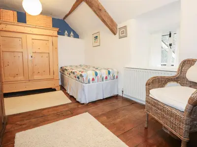 a bedroom with a bed and a chair in a room at Tafarn Trip in Blaenau-Ffestiniog