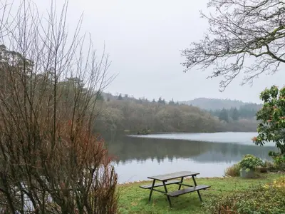 a picnic table sitting next to a lake at Tafarn Trip in Blaenau-Ffestiniog