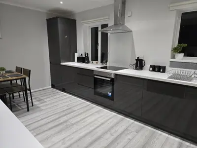 a kitchen with black cabinets and a wooden floor at Shrewsbury Creations in Shrewsbury